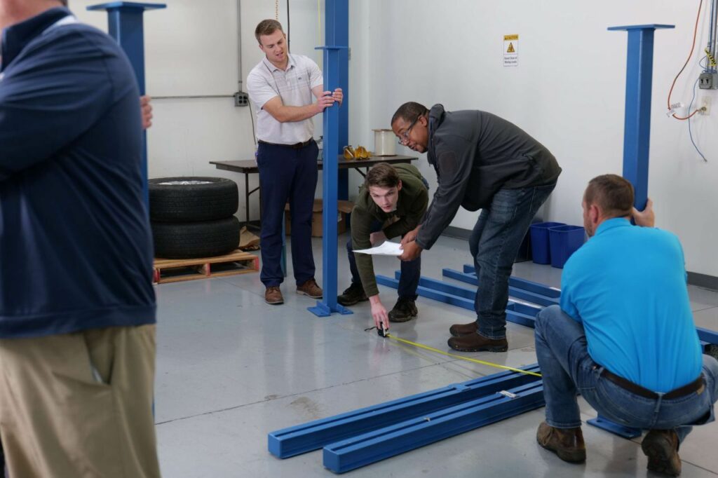 Hands-on in Gorbel's demo area: distributor teams construct a workstation crane from the floor up. Second from right: CESL’s Lead, Marvin Mc Intosh.